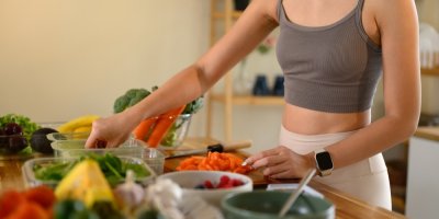 Žena připravuje jídlo z čerstvé zeleniny