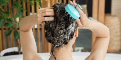 Mladá žena si myje vlasy