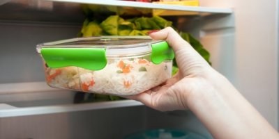 Ruka dává rýži v krabičce do lednice