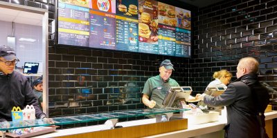 Člověk si objednává u pokladního jídlo v McDonald’s