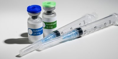 Lahvičky s lékem Retatrutid a injekční stříkačky 