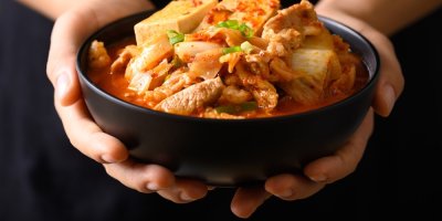 Ruce držící kimchi polévku