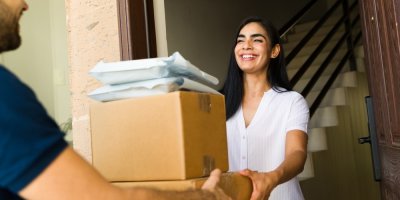 Zákaznice přebírá od kurýra zásilku