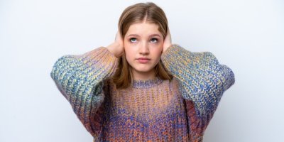 Dívka si zakrývá uši