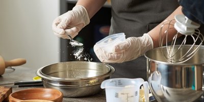 Kuchař přidává prášek do pečiva do mísy