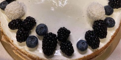 Detail pečeného dortu s bílou polevou a ovocem