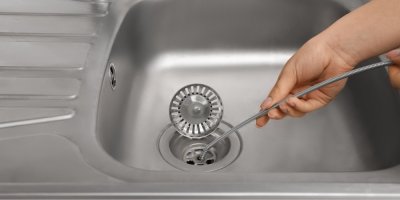 Žena čistí dřezový sifon