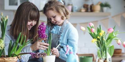 Žena s holčičkou sadí květiny