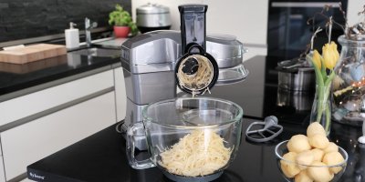 Kuchyňský robot strouhající brambory do skleněné mísy