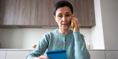 Žena drží v rukou kartu a telefonuje