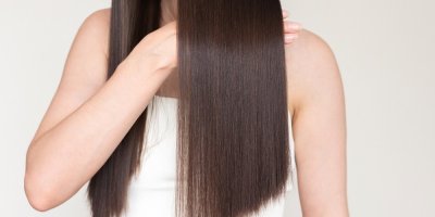 Žena s dlouhými lesklými hnědými vlasy