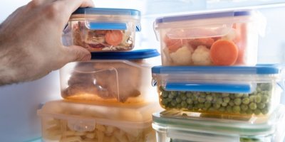 Muž ukládá jídlo v krabičce do lednice