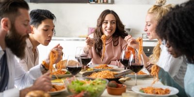 5 lidí okolo stolu jí špagety s boloňskou omáčkou