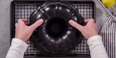 Člověk vyklápí bábovku z černé formy