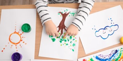 Dítě maluje prstovými barvami