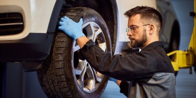 Muž v pneuservisu vyměňuje pneumatiku