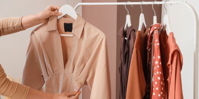 Ruce drží béžové šaty