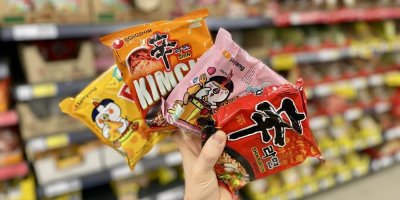 Ruka držící instantní nudle v sáčcích v supermarketu