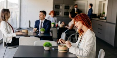 Žena obědvá v práci v jídelním prostoru