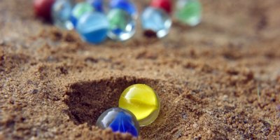 Barevné skleněné kuličky na písku