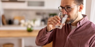 Muž pije vodu ze sklenice