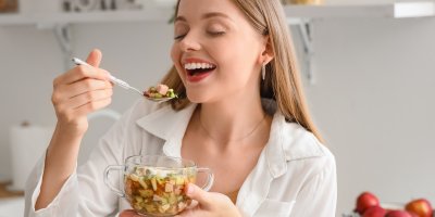 Žena jí jídlo z průhledného hrnečku