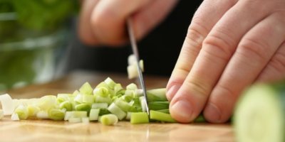 Kuchař krájí jarní cibulku