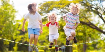 Děti skáčou venku přes švihadlo