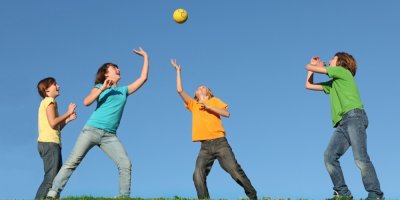 Skupina dětí si hází s míčem