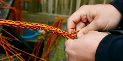 Muž plete pomlázku z proutí