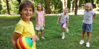 Děti si venku hrají v míčem