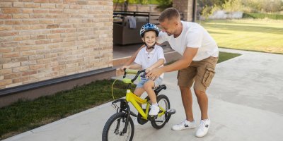 Otec učí chlapce na kole