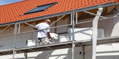 Dělník izoluje fasádu domu