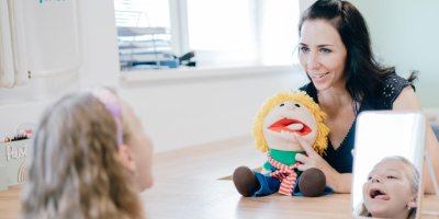 Žena učí dívku logopedii