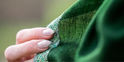 Detail zelené kašmírové šály a ženské ruky