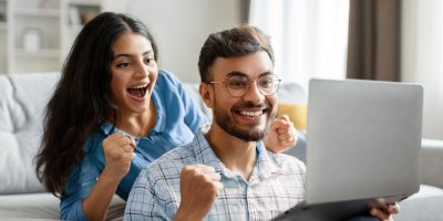 Pár se raduje před notebookem