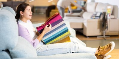 Zákaznice si v prodejně nábytku vybírá pohovku