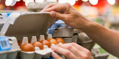 Ruce otevírají vejce v proložce