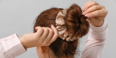 Žena si dělá drdol ve vlasech