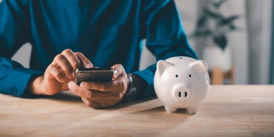 Muž s mobilním telefonem vedle prasátka