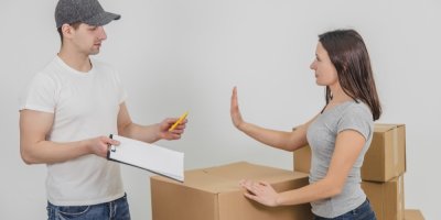 Mladá žena odmítá kurýrovi podepsat formulář pro převzetí zásilky