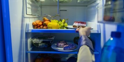 Žena si bere z ledničky dezert