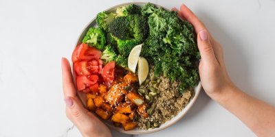 Ženské ruce a talíř plný zdravého jídla