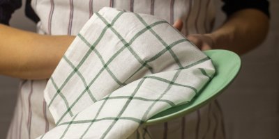 Člověk utírá talíř utěrkou