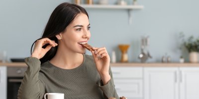 Žena ukusuje kousek čokolády