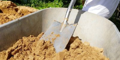 Nabírání písku lopatou z kolečka 