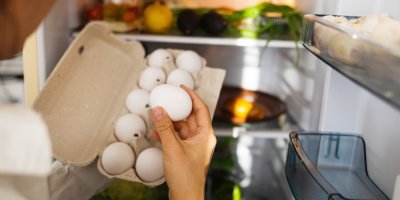 Žena vytahuje vejce z lednice