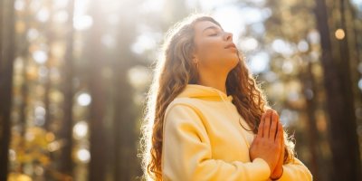 Mladá žena provádí dechové cvičení v přírodě