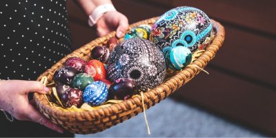 Žena drží velkonoční kraslice v ošatce