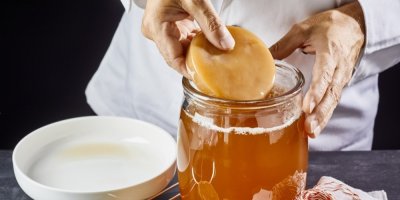 Muž dává houbu kvasit do sklenice